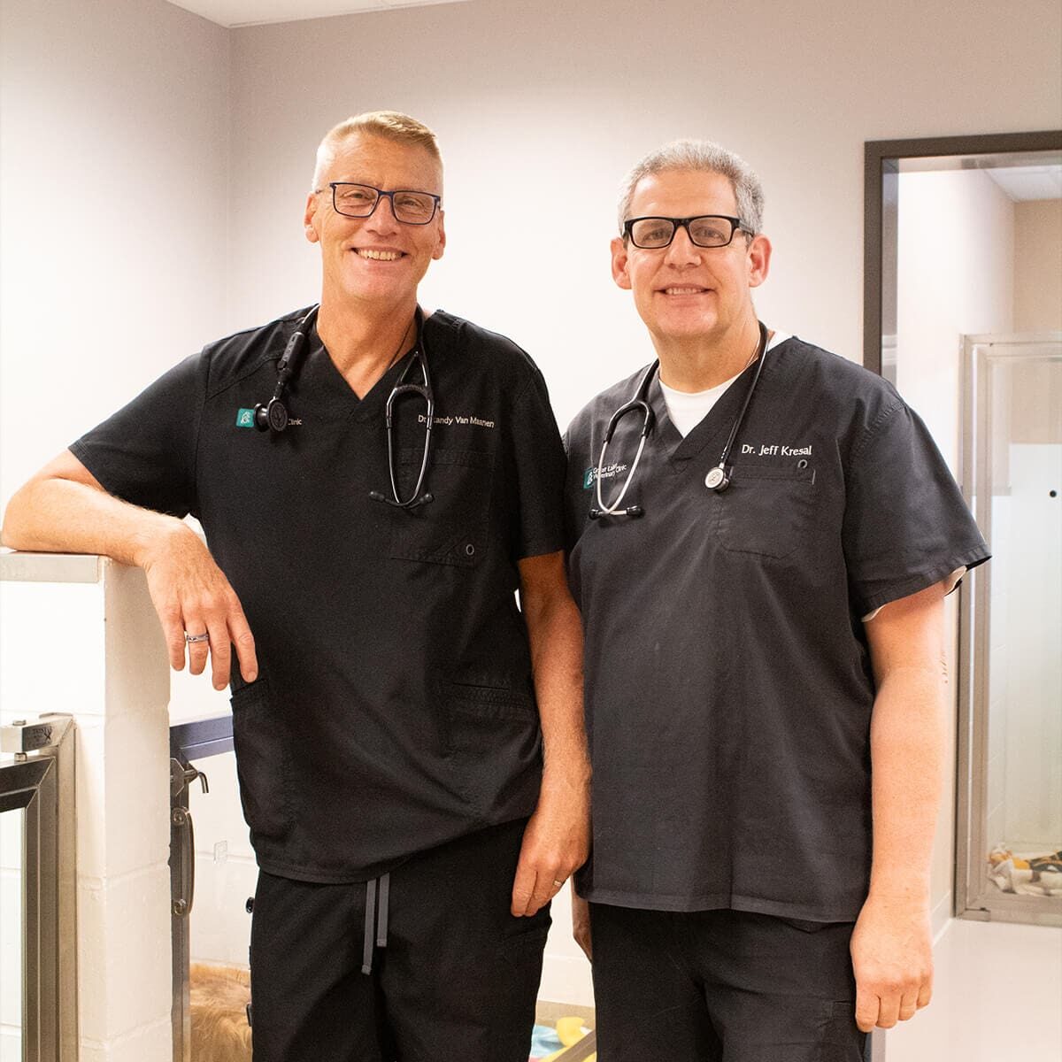 two older male veterinarians smiling for camera